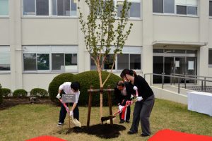 土かけの様子（左より小笠原さん、鶴見校長、荒巻さん）