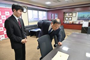 鶴見校長に試作品の説明をする星野君