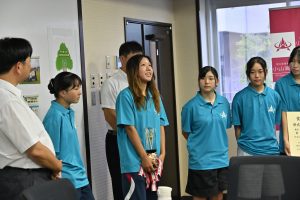 トロフィーを手に校長に優勝を報告する出野さん