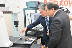 鶴見校長に機器の説明をする加納取締役常務執行役員