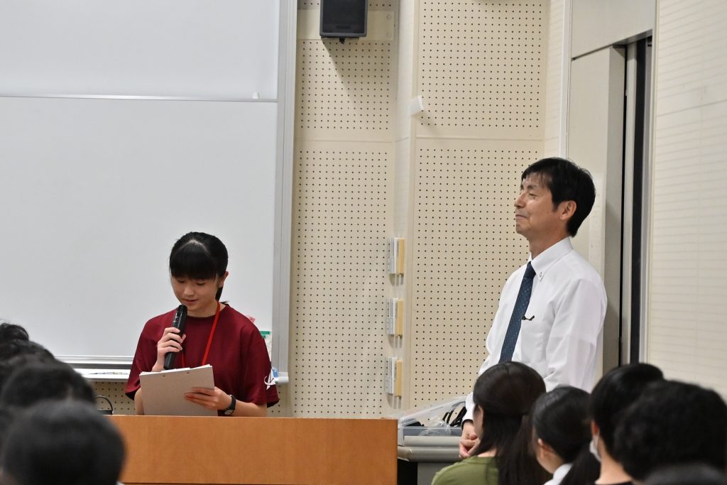 伊澤教務主事が見守る中参加者へメッセージを述べる荒川さん