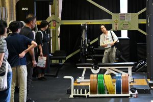 施設見学ツアーも学生が案内（体育館のトレーニングルームを案内する学生会長物質工学科４年小笠原柊太君）